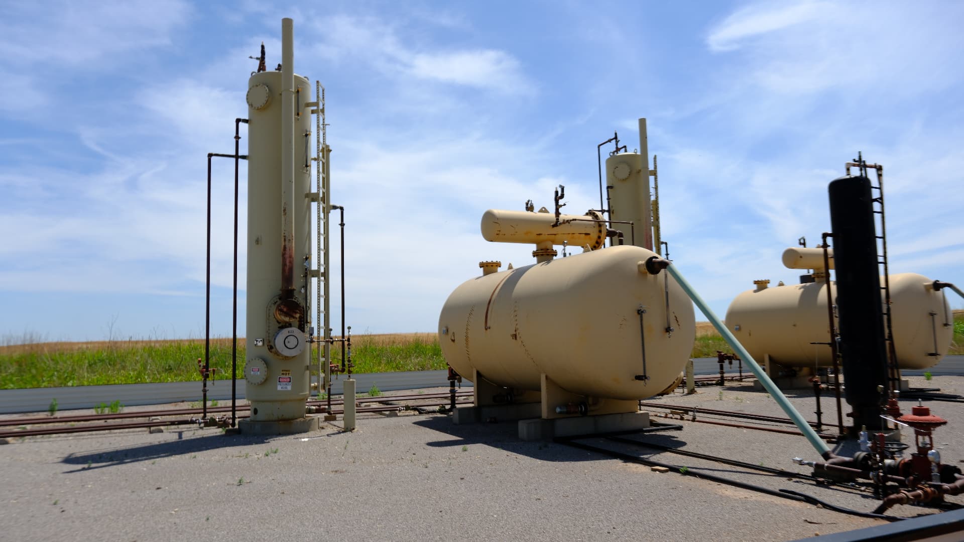 Heater treater and separator vessels under a blue Kansas sky
